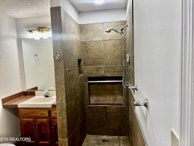 bathroom featuring a shower, a textured ceiling, and vanity