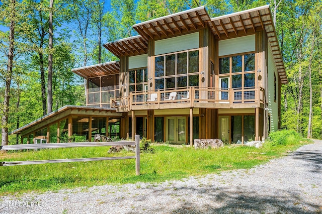 rear view of property with french doors, a deck, and a sunroom