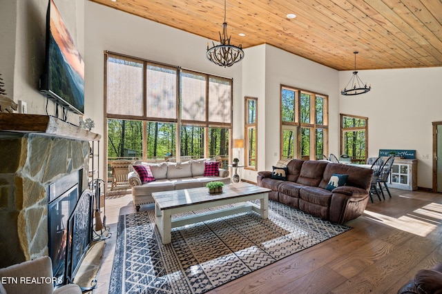 living room with hardwood / wood-style floors, a towering ceiling, wooden ceiling, and a notable chandelier