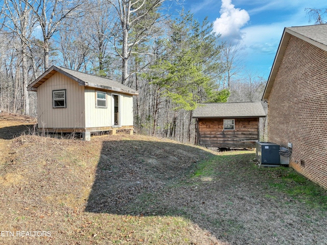 view of yard featuring central AC unit and an outbuilding