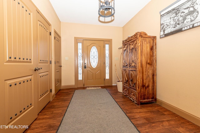 foyer with dark hardwood / wood-style flooring and a chandelier