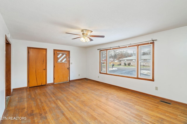 unfurnished bedroom featuring light hardwood / wood-style flooring, ceiling fan, and multiple closets