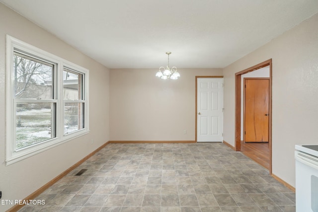 spare room with a notable chandelier