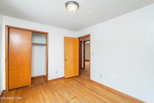 unfurnished bedroom featuring light hardwood / wood-style floors and a closet