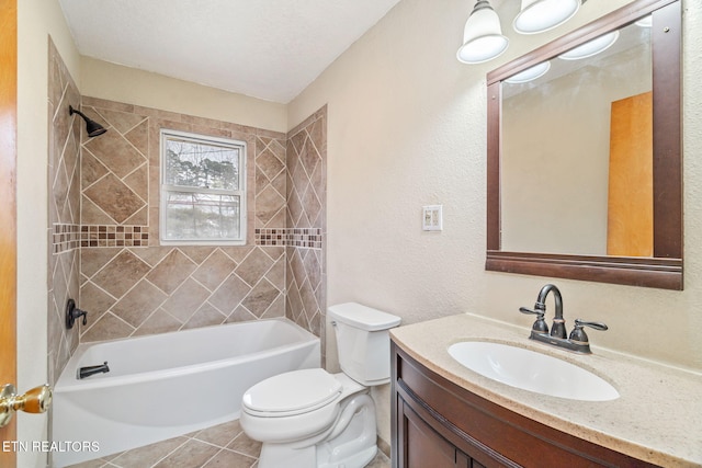 full bathroom with tile patterned flooring, vanity, tiled shower / bath combo, and toilet