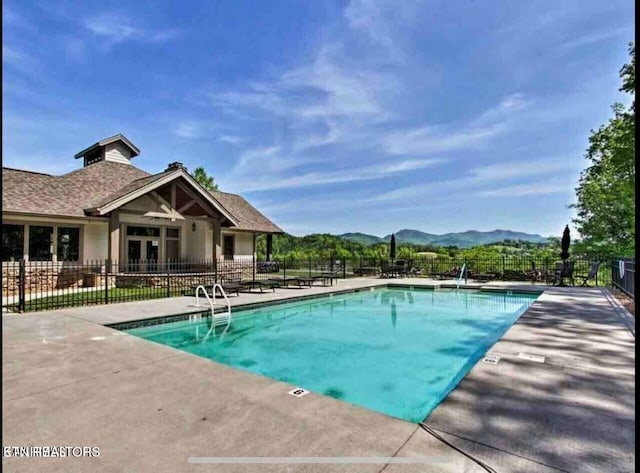 view of swimming pool with a mountain view and a patio