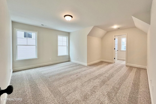 bonus room featuring lofted ceiling and light carpet