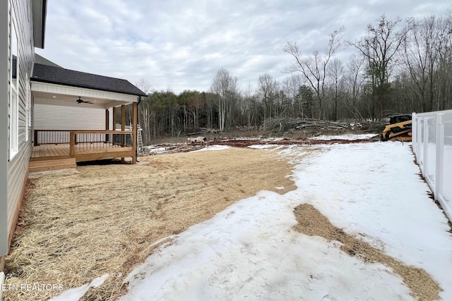 snowy yard with ceiling fan and a deck