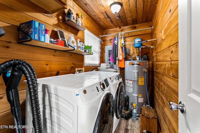 laundry room with wood ceiling, independent washer and dryer, wood walls, and electric water heater