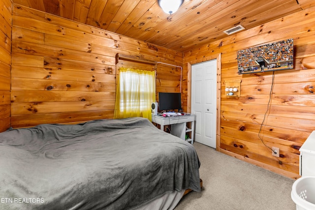 carpeted bedroom with wood ceiling and wooden walls