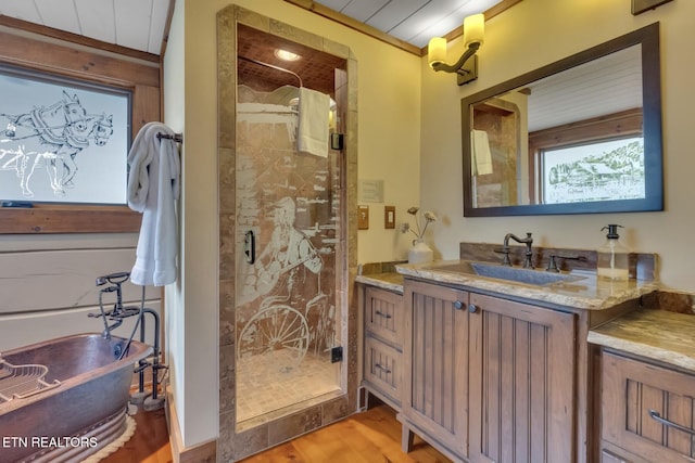 bathroom with hardwood / wood-style floors, vanity, and a shower with shower door