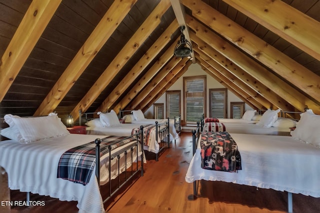 bedroom with lofted ceiling with beams, hardwood / wood-style flooring, and wooden ceiling