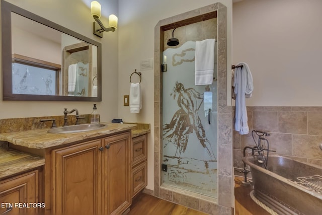 bathroom with vanity, wood-type flooring, and plus walk in shower