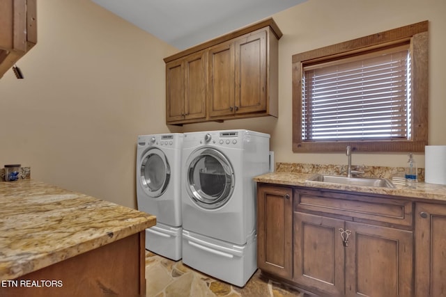 washroom featuring washer and clothes dryer, sink, and cabinets