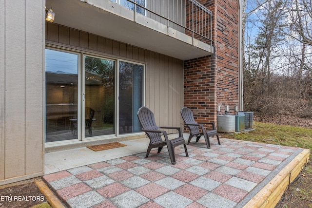 view of patio with a balcony and central air condition unit