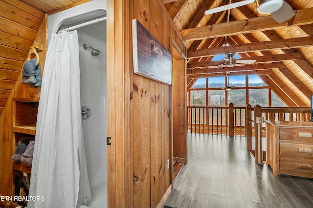 bathroom with lofted ceiling with beams, wooden ceiling, and wooden walls