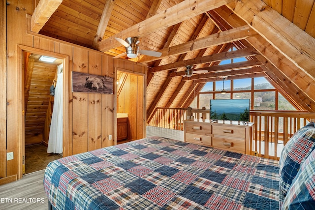 bedroom with vaulted ceiling with beams, wood walls, wooden ceiling, and light hardwood / wood-style floors