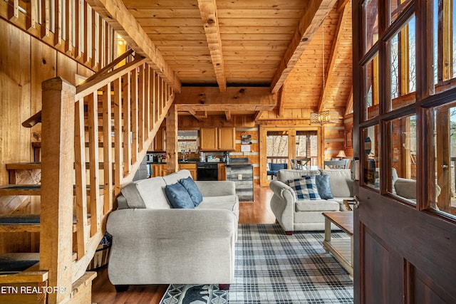 living room with wood walls, wooden ceiling, dark hardwood / wood-style floors, a towering ceiling, and beam ceiling