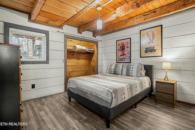 bedroom featuring wooden walls, beam ceiling, hardwood / wood-style flooring, wooden ceiling, and a closet