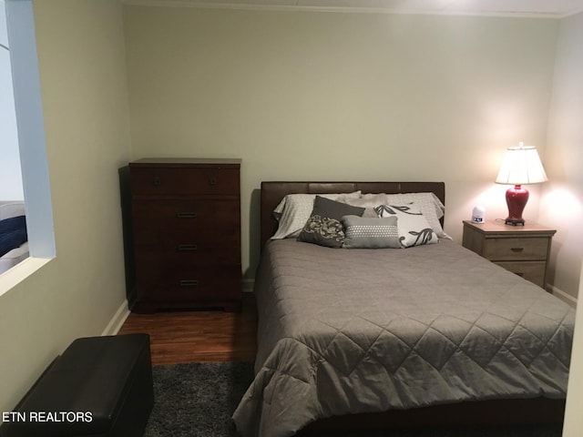 bedroom with dark wood-type flooring and crown molding