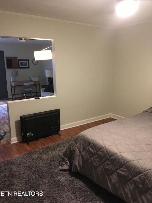 bedroom featuring dark hardwood / wood-style floors and ornamental molding