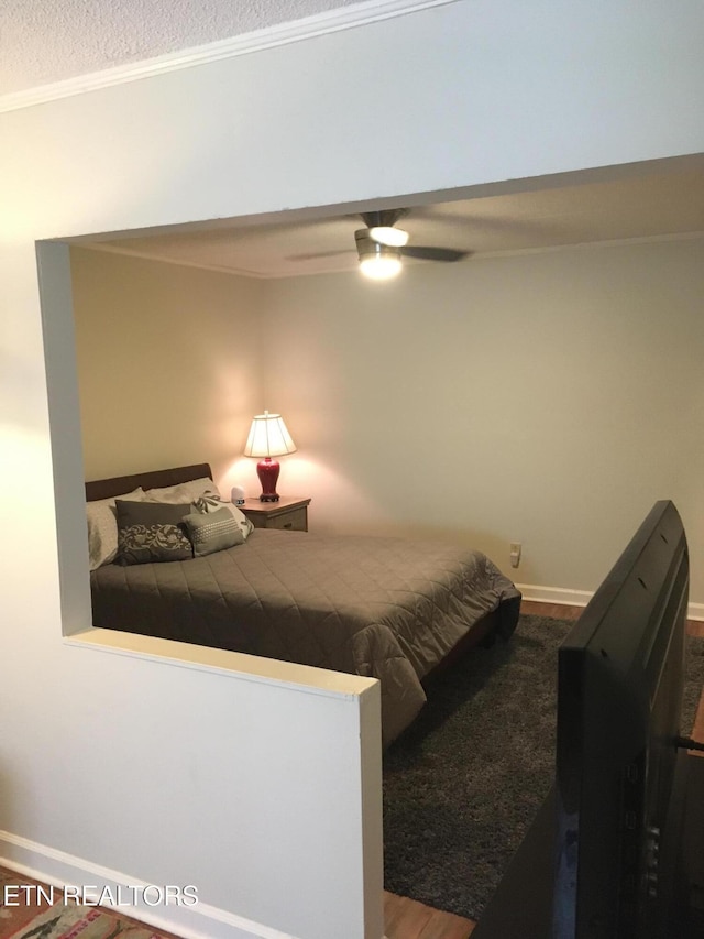 bedroom with hardwood / wood-style floors, ceiling fan, crown molding, and a textured ceiling