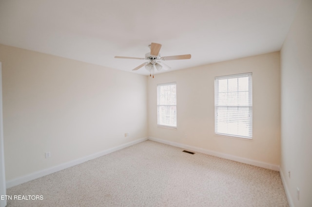 carpeted spare room with ceiling fan