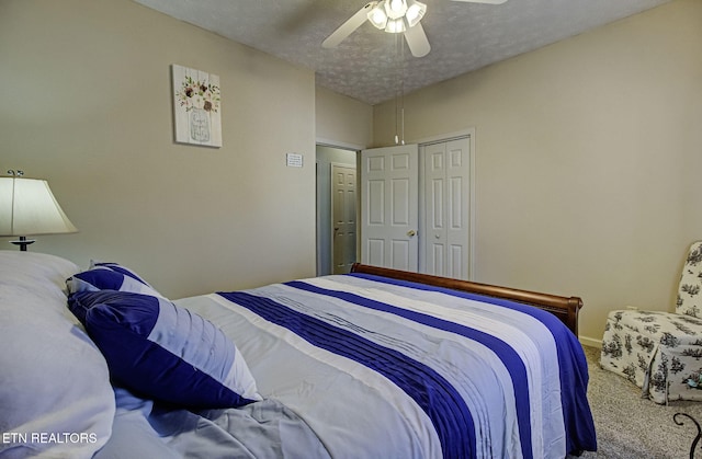 bedroom with a textured ceiling, carpet floors, a ceiling fan, baseboards, and a closet