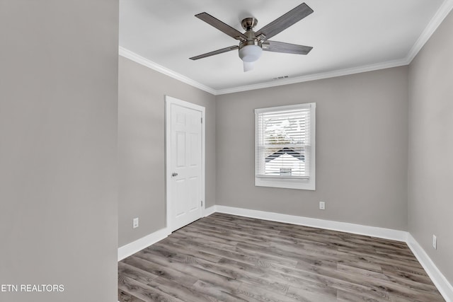 empty room with ceiling fan, crown molding, and hardwood / wood-style flooring