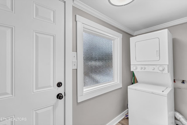 washroom featuring ornamental molding and stacked washer and clothes dryer