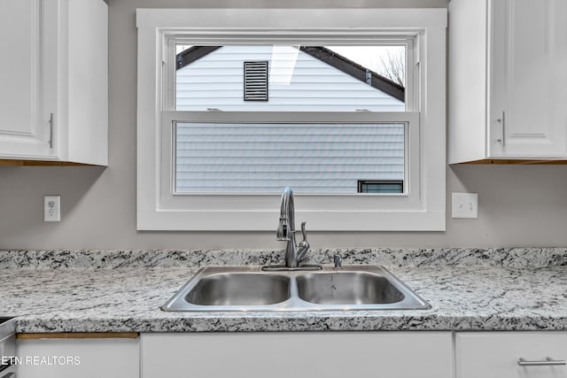 kitchen featuring white cabinets and sink