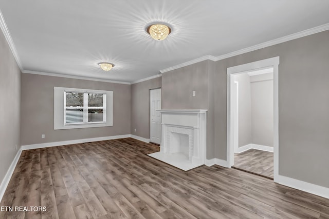 unfurnished living room featuring crown molding, hardwood / wood-style flooring, and a brick fireplace