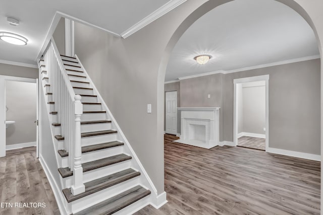 stairs featuring crown molding and wood-type flooring