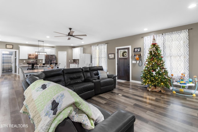 living room with ceiling fan, dark hardwood / wood-style flooring, and plenty of natural light