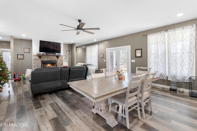 dining space with a fireplace, ceiling fan, and hardwood / wood-style floors