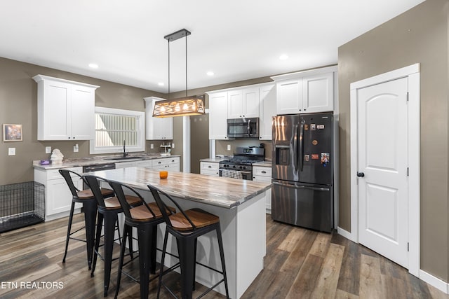499 Woodland Trl, Sunbright, TN 37872 - kitchen featuring stainless steel appliances, a center island, white cabinetry, a kitchen breakfast bar, and dark wood-style floors