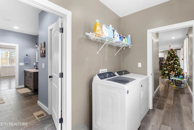 laundry area with sink, washer and dryer, and wood-type flooring