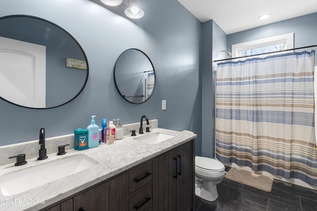 bathroom featuring curtained shower, vanity, and toilet