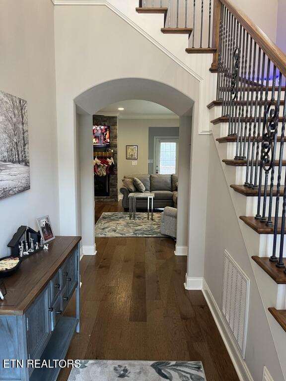 interior space with crown molding and dark wood-type flooring