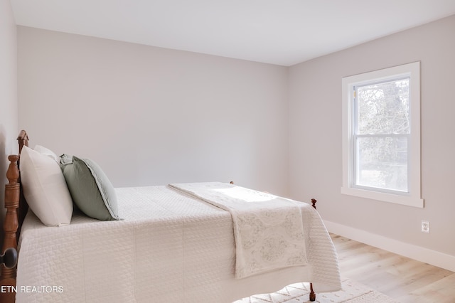 bedroom with light wood-type flooring and multiple windows