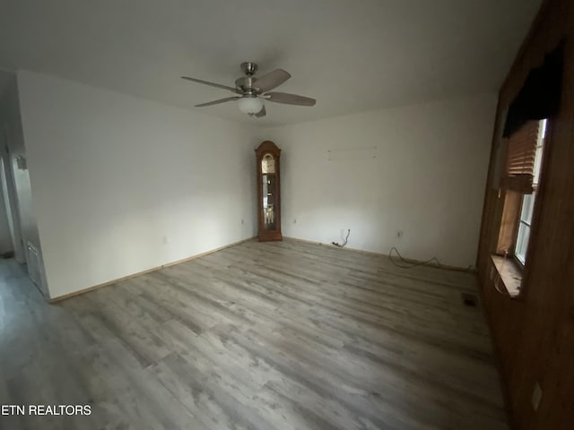 spare room with ceiling fan and light wood-type flooring