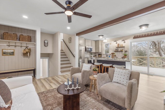 living area with light wood-style floors, ceiling fan, stairway, and recessed lighting