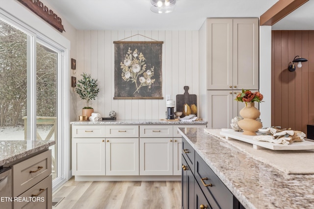 kitchen with light stone counters, gray cabinets, and light wood-style floors