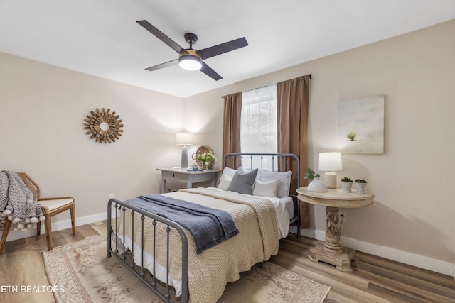 bedroom featuring wood finished floors, a ceiling fan, and baseboards