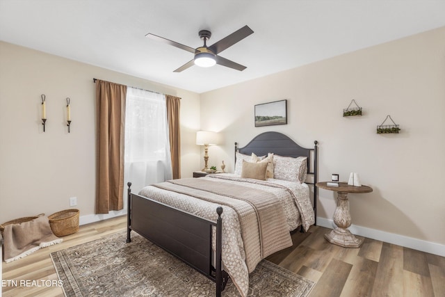 bedroom with a ceiling fan, baseboards, and wood finished floors