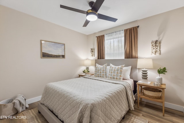 bedroom featuring a ceiling fan, baseboards, and wood finished floors