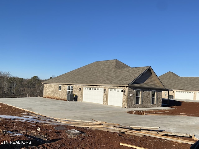 view of front of home featuring central AC unit and a garage