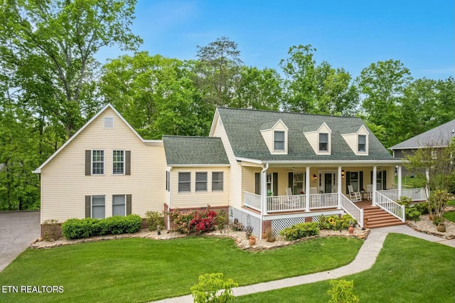 cape cod home with covered porch and a front lawn