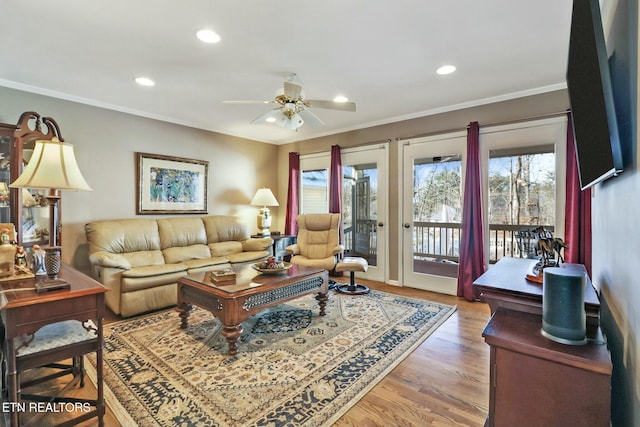 living room with ceiling fan, crown molding, and wood-type flooring