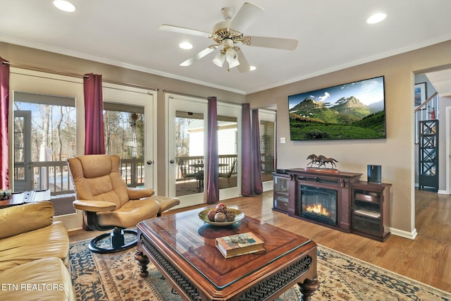 living room featuring wood-type flooring, french doors, ceiling fan, and crown molding